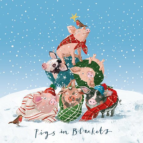 Christmas card design showing pigs wearing knitted blankets in the snow, text reads 'Pigs in Blankets'.