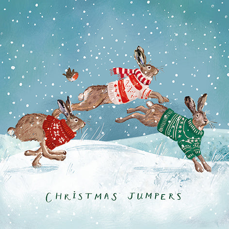 Christmas card design showing hares wearing jumpers and scarves in the snow, text reads 'Christmas Jumpers'.