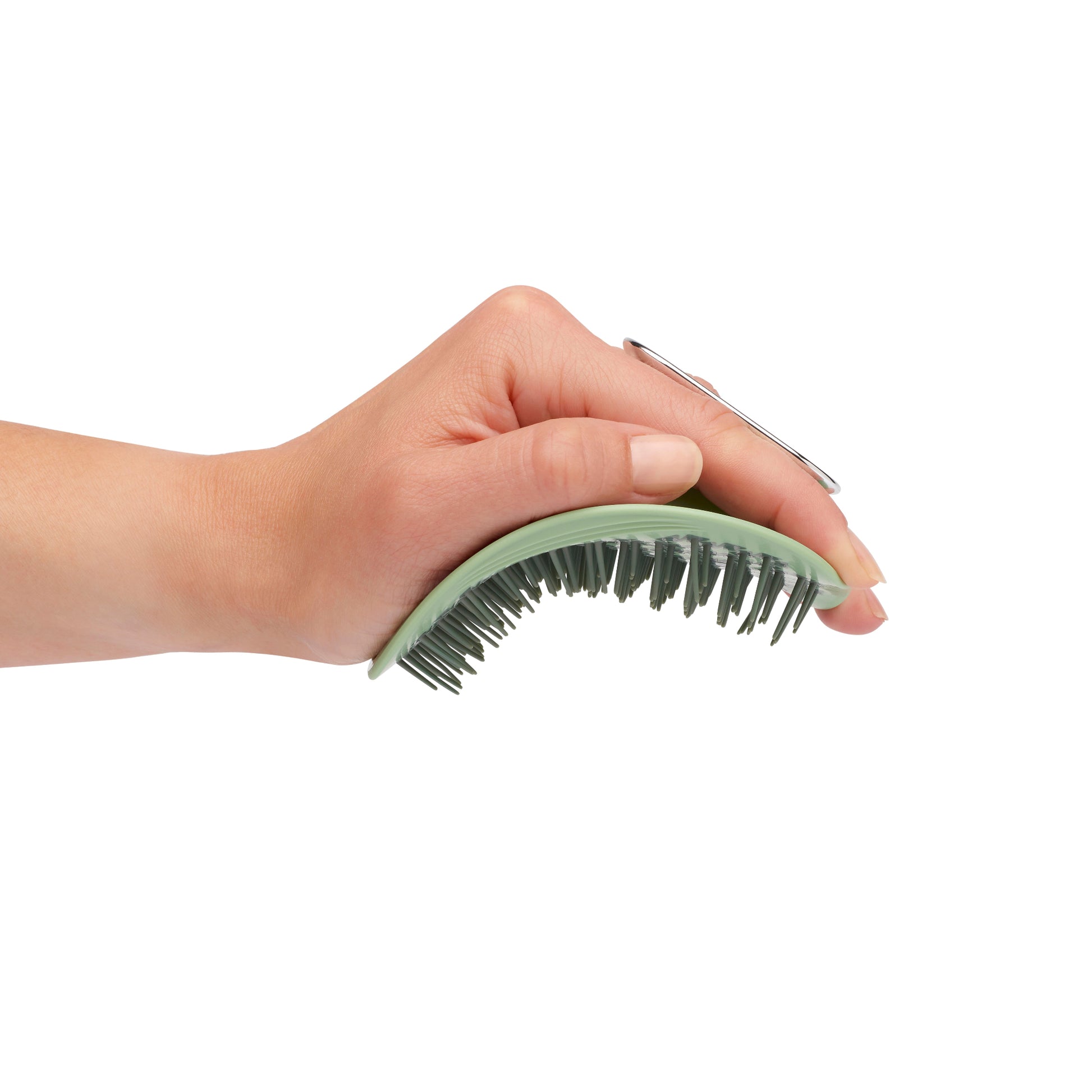 MANTA brush with a non-slip handle in green and white gold being flexed in a hand. 