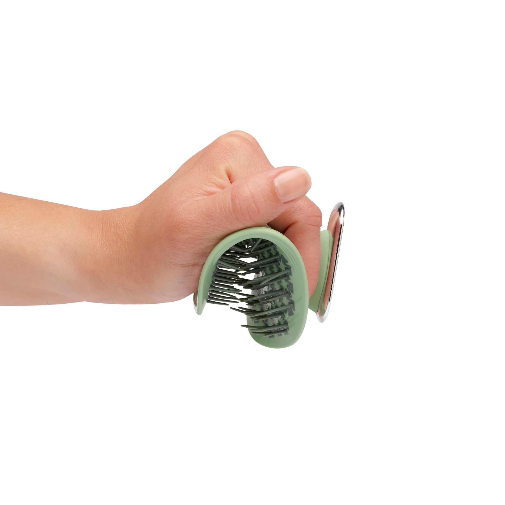 MANTA brush with a non-slip handle in green and white gold being flexed in a hand. 