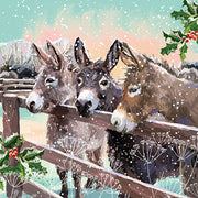 Christmas card design showing three donkeys standing by a fence in the snow.