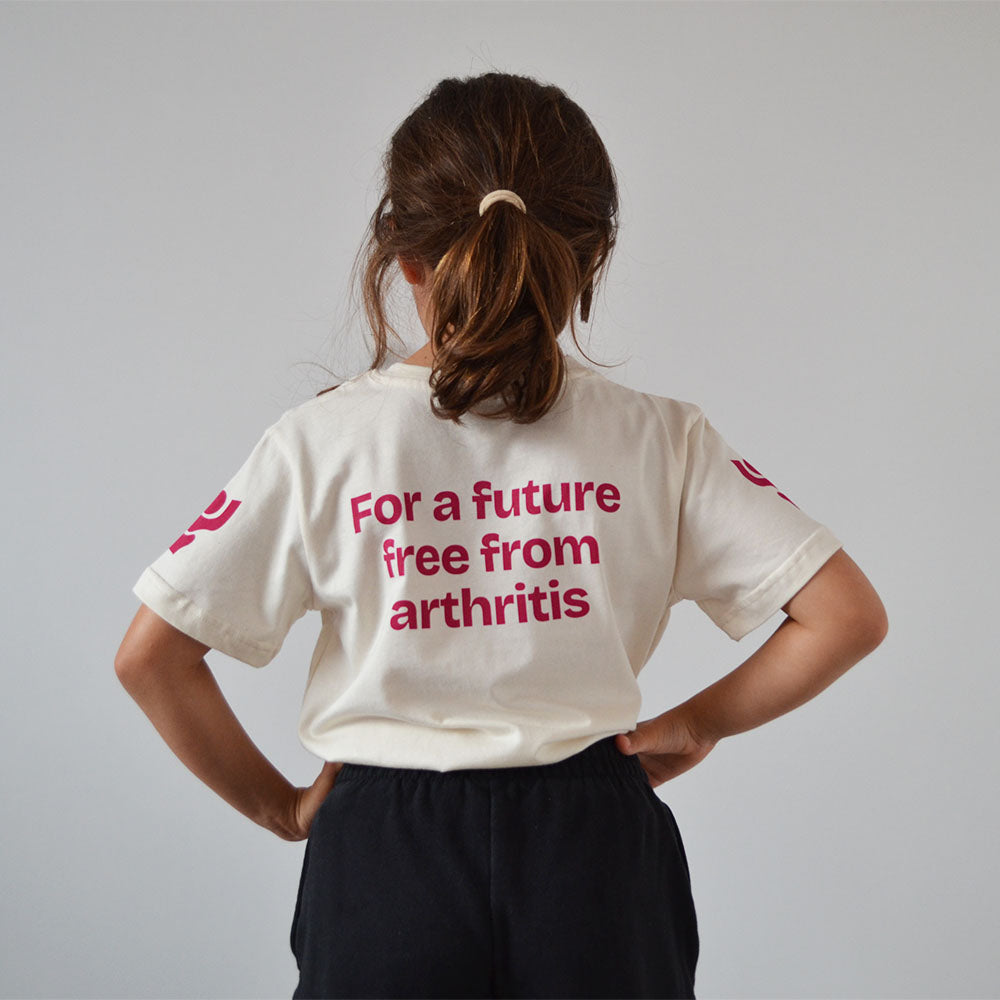 Person wearing an off-white Arthritis UK t-shirt with raspberry text 'For a future free from arthritis' on the back.