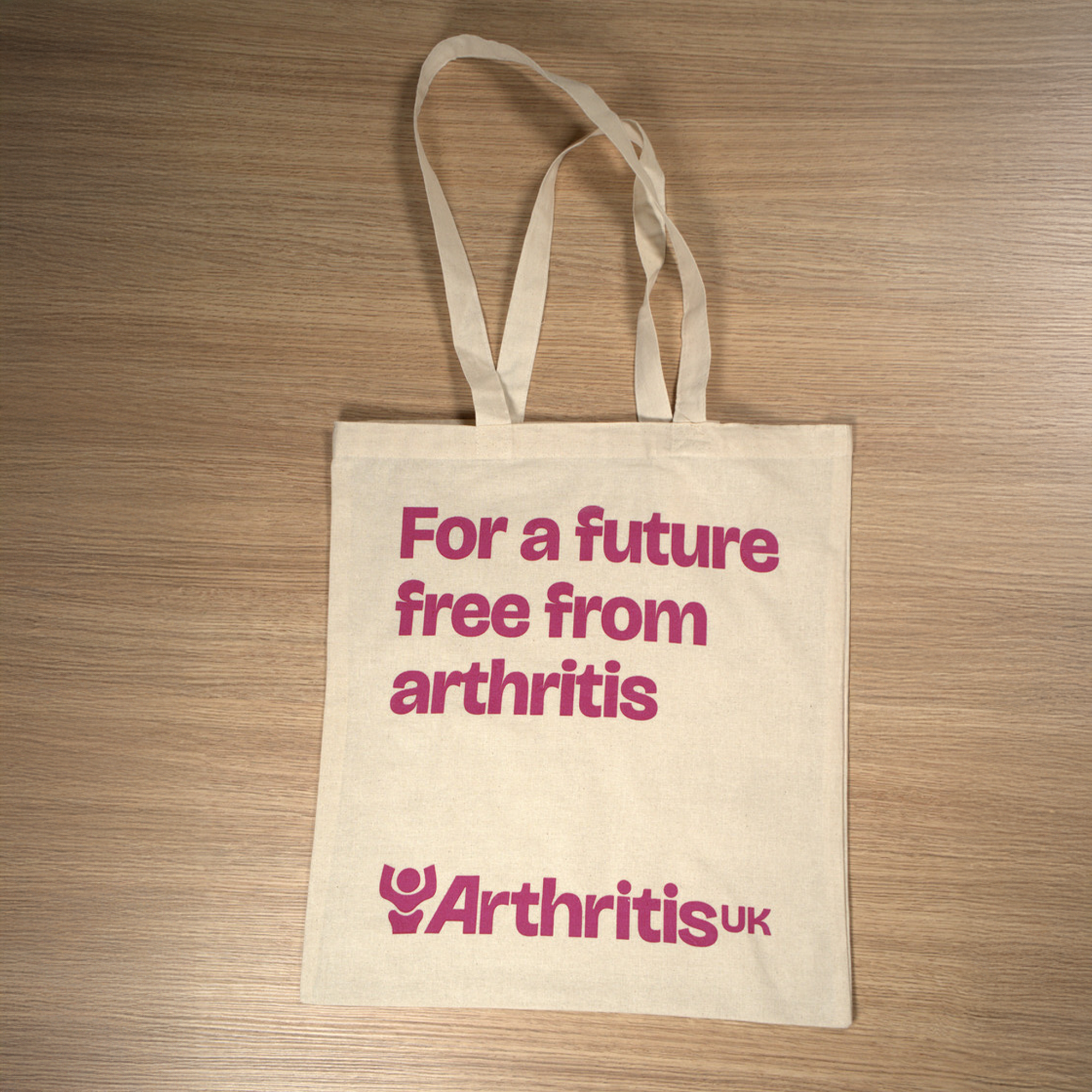 Flat lay of Arthritis UK tote bag, reading showing logo and 'For a future free from arthritis'.