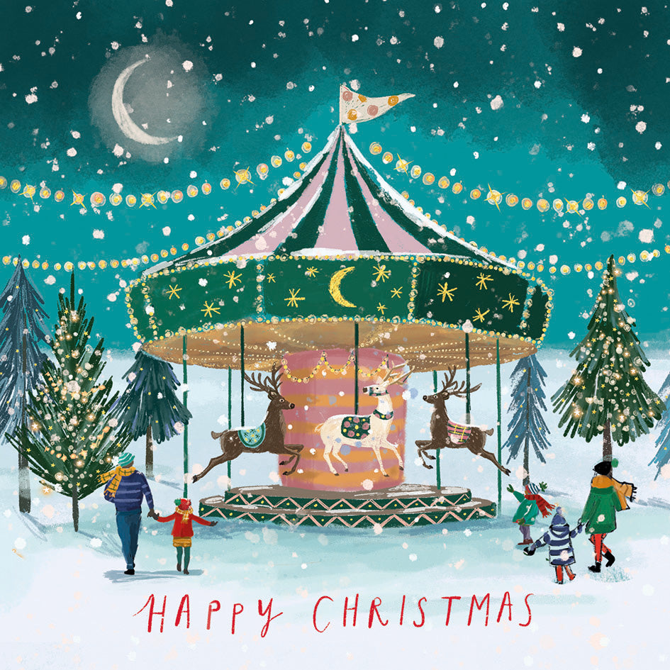 Front cover of the Arthritis UK Christmas Card 'Christmas Carousel' featuring a festive fairground ride in a snowy landscape, with the text 'Happy Christmas'. 
