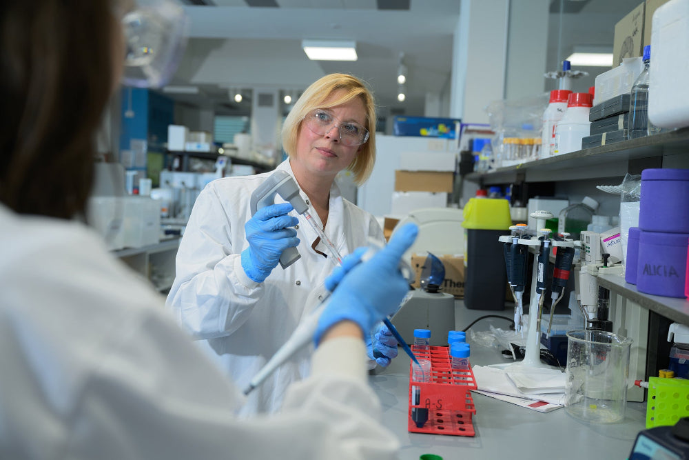 Person in a laboratory setting with scientific equipment and supplies.