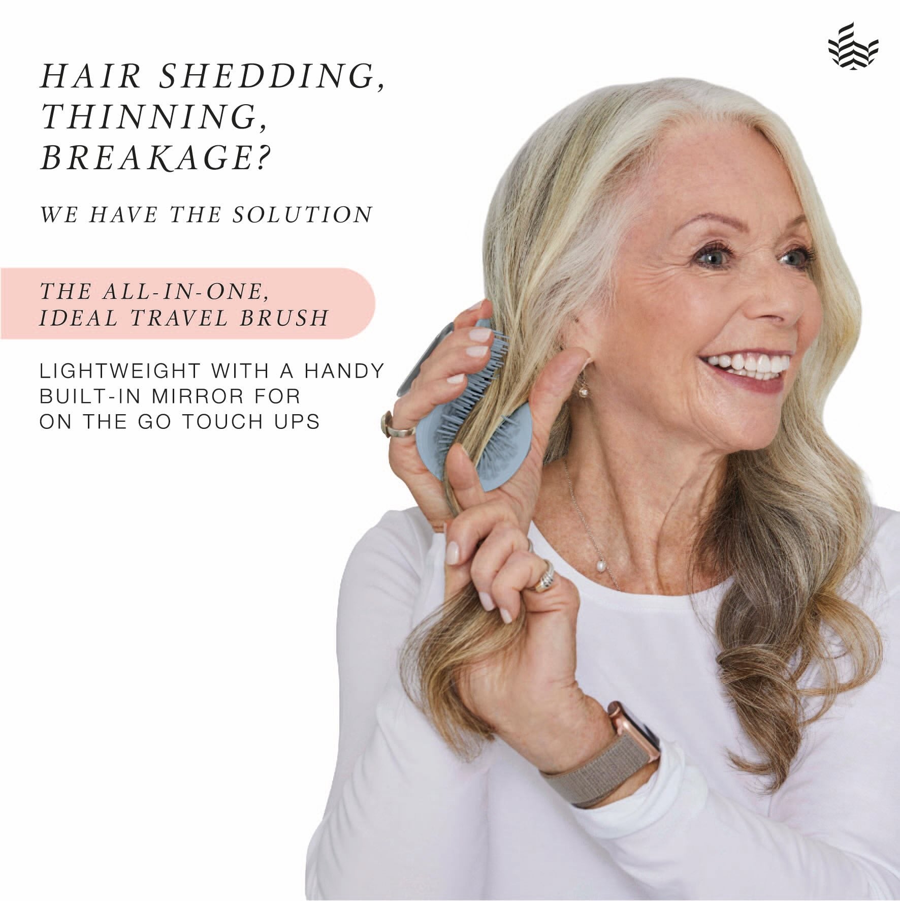 Woman brushing her hair with a manta mirror travel brush.