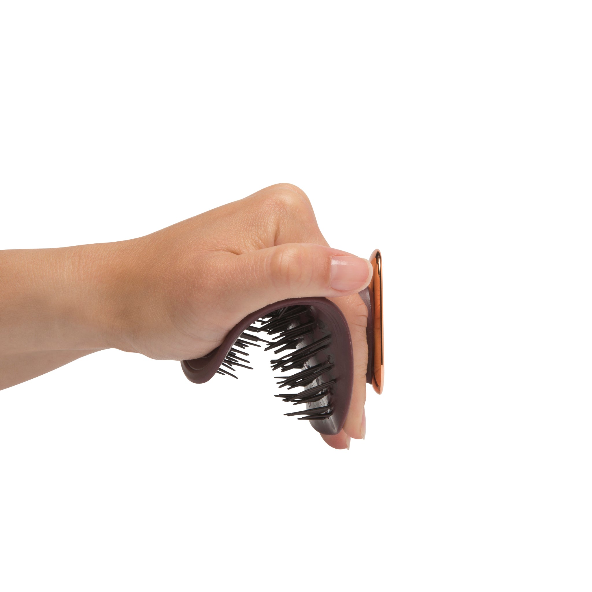 MANTA easy grip brush in burgundy and rose gold, being held and flexed in the hand.