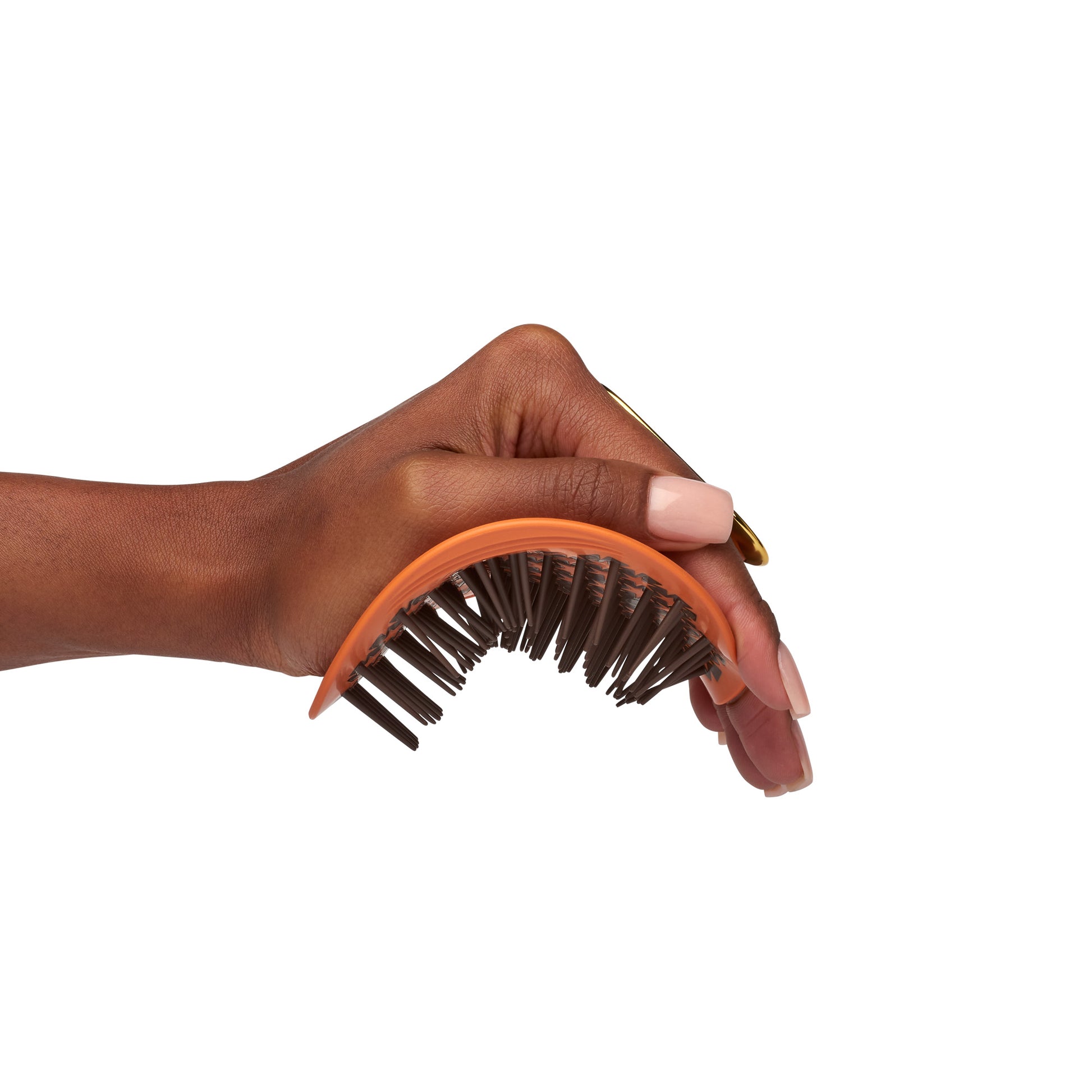 MANTA curls easy grip brush for 3A to 4C hair in amber orange, being flexed in the palm of the hand. 