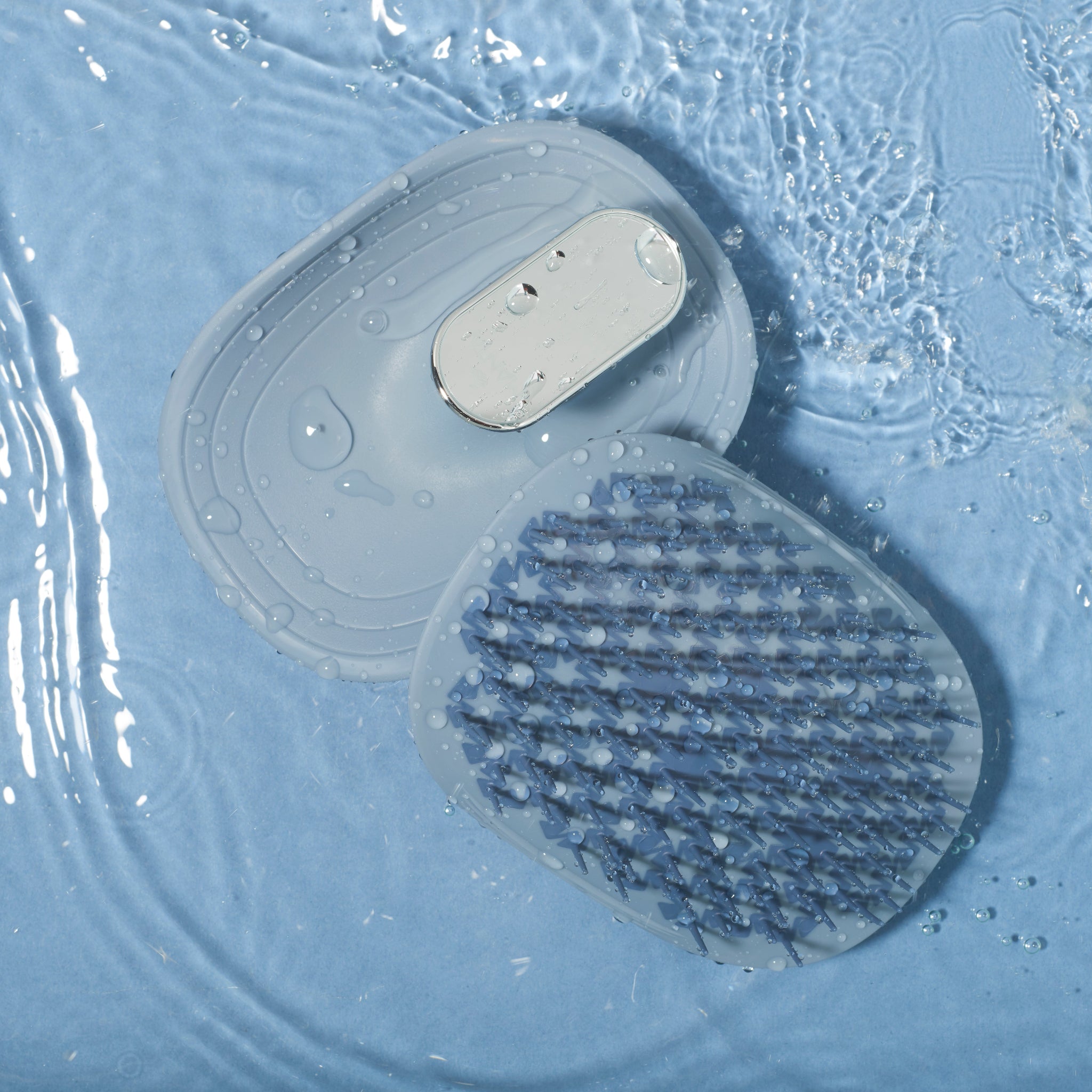 MANTA mirror travel easy grip brush in blue and white gold in water. 