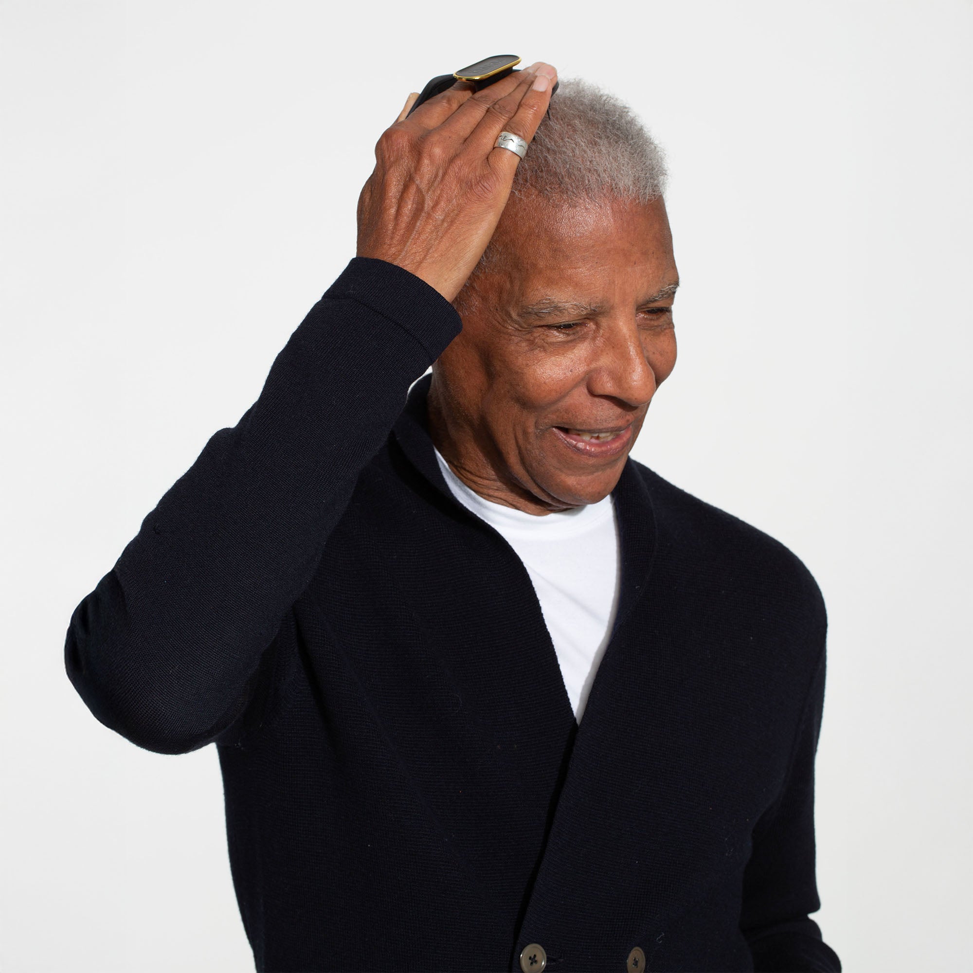 Man brushing his hair with the MANTA brush in black and gold. 