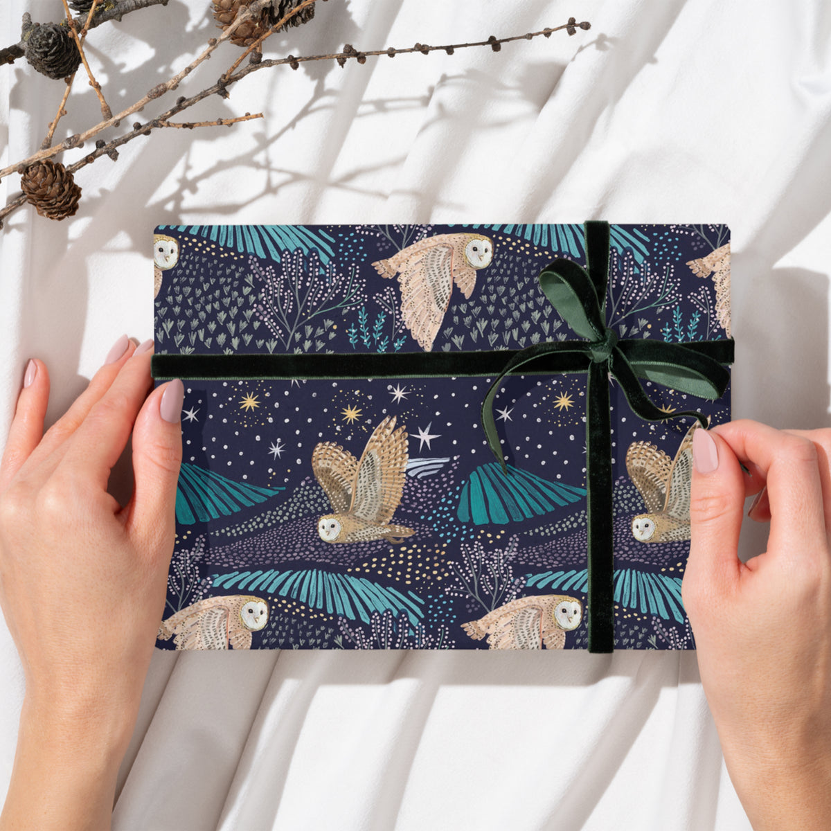 Gift wrap featuring owls swooping across starlit fields. 