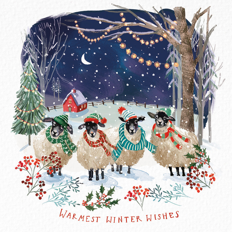 Front cover of the Arthritis UK Christmas Card 'Warm Winter' featuring four sheep standing in a snowy field in front of a farmhouse, wearing hats and scarves, and featuring the text 'Warmest Winter Wishes'. 