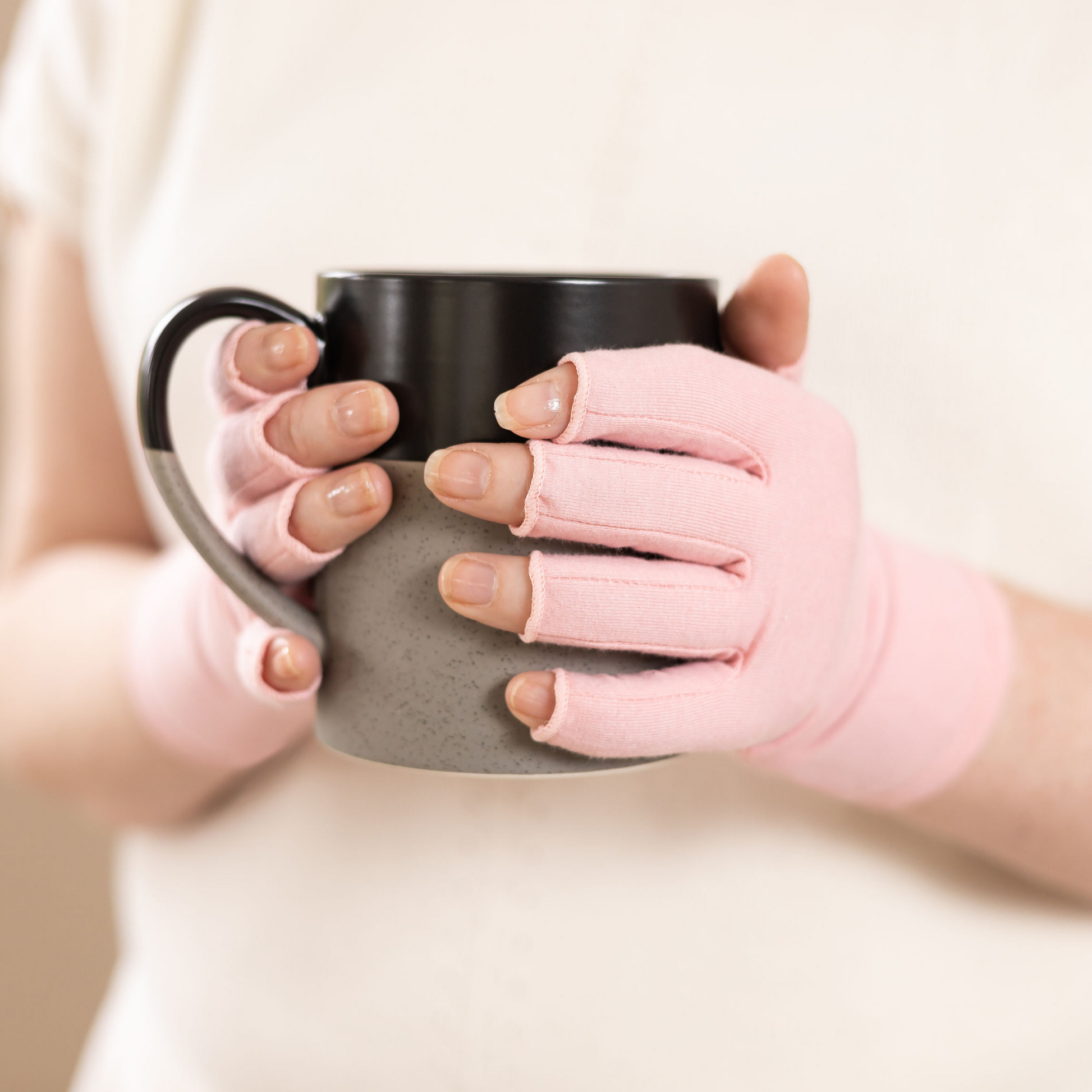 Ballet pink compression gloves being used while drinking a mug of tea. 