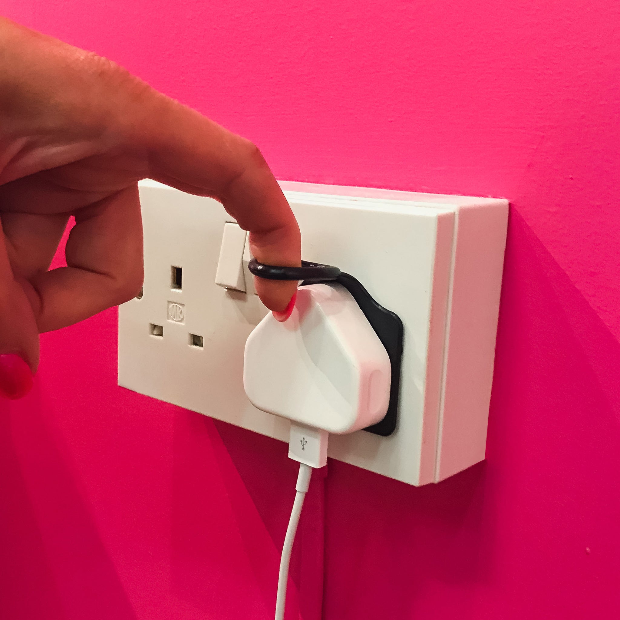 Plugull plug pull attachment in black being used to remove a plug from a socket.